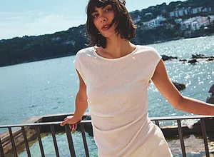 Lätt, vit sommaroutfit: luftig T-shirt och bekväma byxor för en avslappnad dag vid havet.