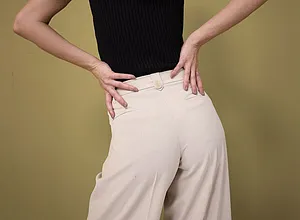 Elegant kontrast: svart, ärmlös topp möter vida, naturfärgade byxor med hög midja.