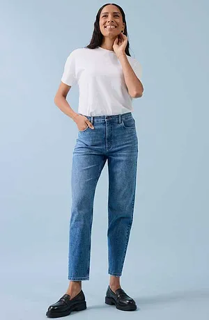 Ledig look med vit T-shirt, blåa jeans och svarta skor.