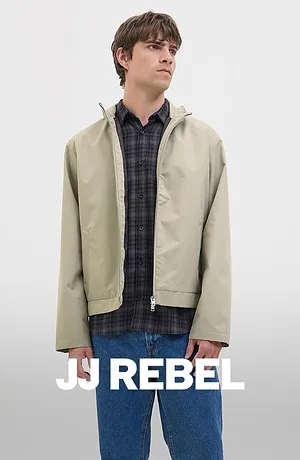 Rutig skjorta under en beige jacka, kombinerat med blå jeans.
