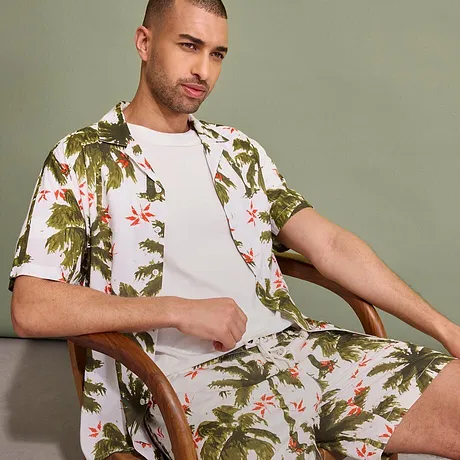 Tropisk skjorta och shorts med palmmönster, med en enfärgad vit T-shirt under.