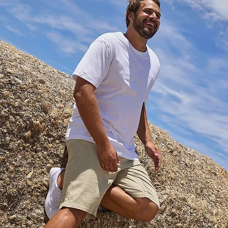 En enkel vit T-shirt och beige shorts - perfekt för en solig dag på stranden.