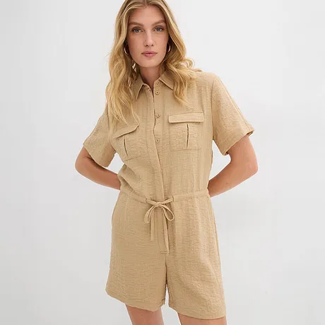 En beige kortärmad jumpsuit med krage, knytband i midjan och bröstfickor.