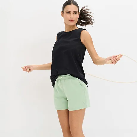 En svart topp kombinerad med mintgröna träningsshorts.