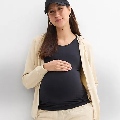 Bekväma mammakläder: Naturfärgad cardigan och byxor, mörk topp och sportig keps.