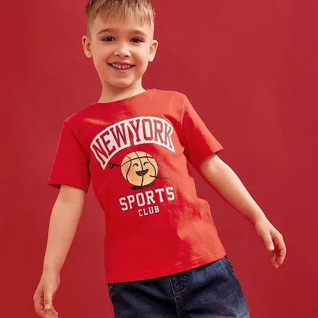 Röd T-shirt med texten "New York Sports Club" kombinerat med blå jeans.