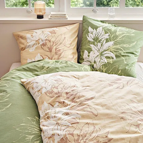 Blommigt påslakanset i pastelltoner: grönt och beige med skirt blommönster pryder sängen.