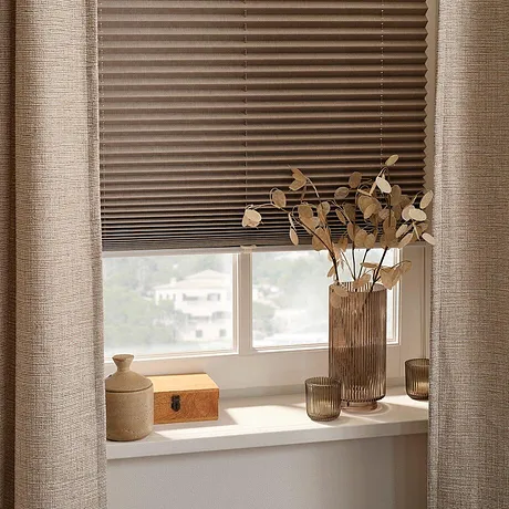 Naturliga färger och texturer: plissérade, tunna gardiner och torkade blommor pryder fönstret med stil.