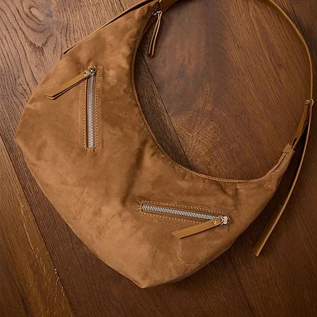 Elegant brun läderväska med flera dragkedjor.