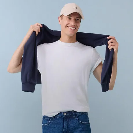 Vit t-shirt, blå jeans och mörk tröja.

