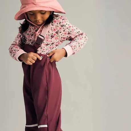 Färgglad look: Rosa blommönstrad tröja, vinröd regnbyxa och pastellfärgad regnhatt.