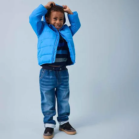 Blå dunjacka, randig tröja och jeans - glada barnkläder för kalla dagar.