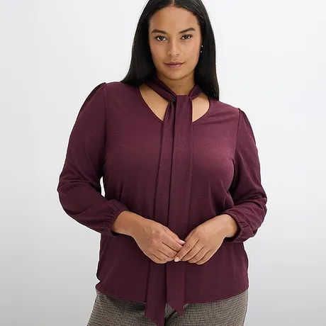 Elegant vinröd blus med knytkrage.

