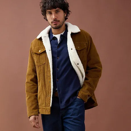 Brun manchesterjacka med teddyfoder över blå tröja.