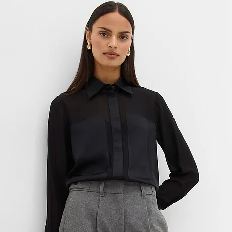 Svart blus kombinerad med grå byxor.

