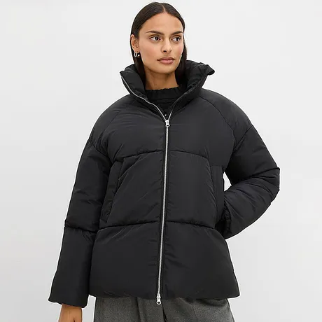 Svart jacka med hög krage och dragkedja.

