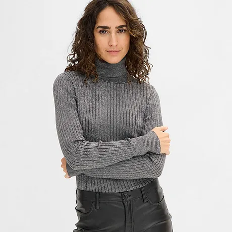 Grå polotröja kombinerad med svarta läderbyxor.

