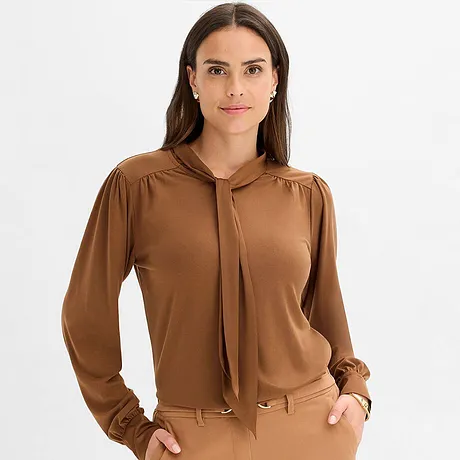 Brun tröja med knytkrage och långa ärmar.

