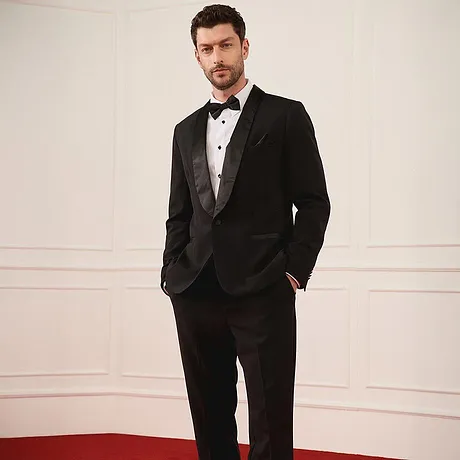 Elegant svart smoking med fluga och vit skjorta för fest.

