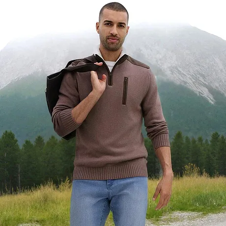 En brun tröja med dragkedja och krage, kombinerat med ljusa jeans.

