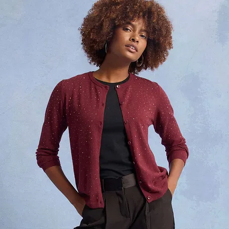 Röd kofta med glittriga utsmyckningar, kombinerat med en svart topp.

