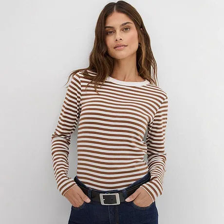 Randig långärmad tröja i brunt och vitt, kombinerad med mörka jeans och skärp.

