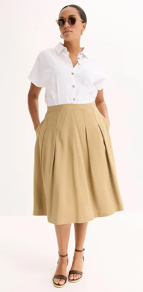 Elegant sommarlook: Vit kortärmad skjorta kombinerad med en beige midikjol och svarta sandaler.