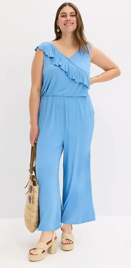 Ljusblå jumpsuit med asymmetriska volanger och vida ben. Perfekt sommaroutfit för en avslappnad look.