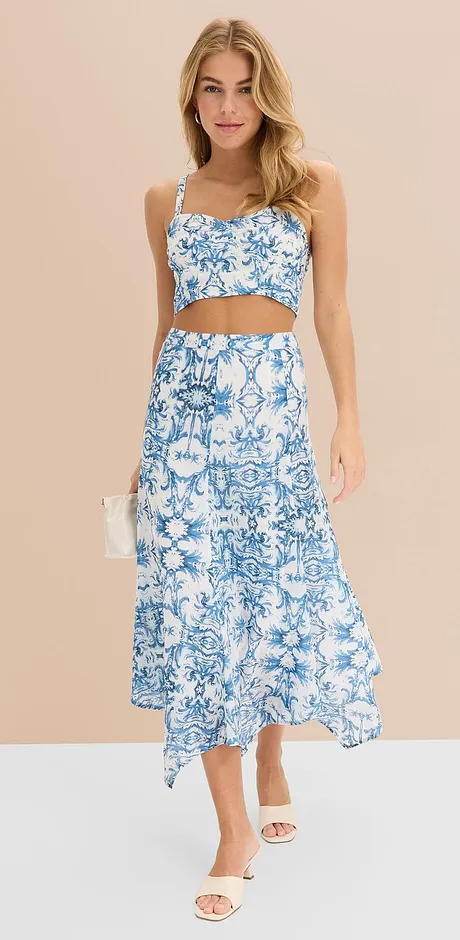 Somrig tvådelad outfit med blåvitt blommönster: crop top och lång kjol med asymmetrisk fåll.