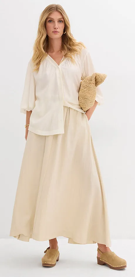 Luftig, naturfärgad sommaroutfit med en vid blus och en lång kjol.