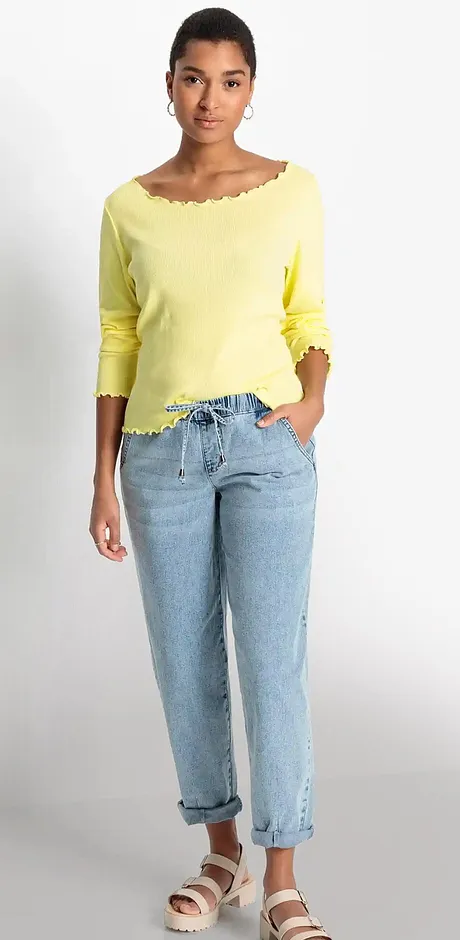 Sommaroutfit: gul singoallatröja, avslappnade ljusblå jeans och bekväma sandaler.