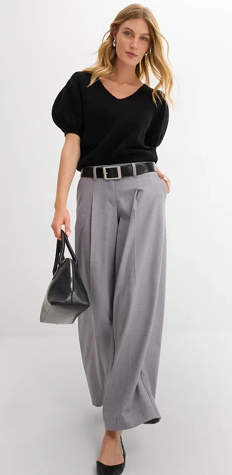 Elegant look med svart blus, vida grå byxor och stilfullt skärp.
