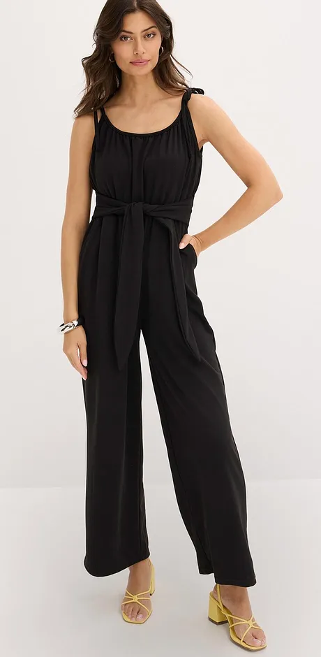 Elegant svart jumpsuit med axelband och vida ben.