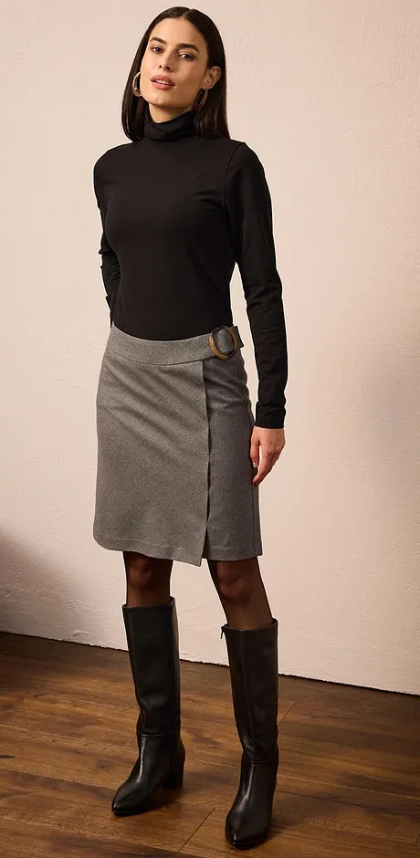 Elegant look med svart polotröja, grå kjol och höga svarta stövlar.