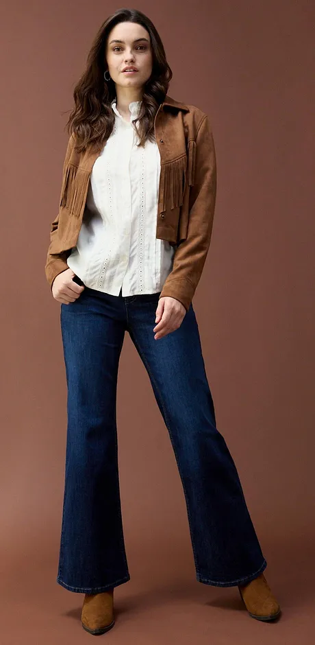Mockajacka över vit blus, kombinerat med utsvängda jeans.