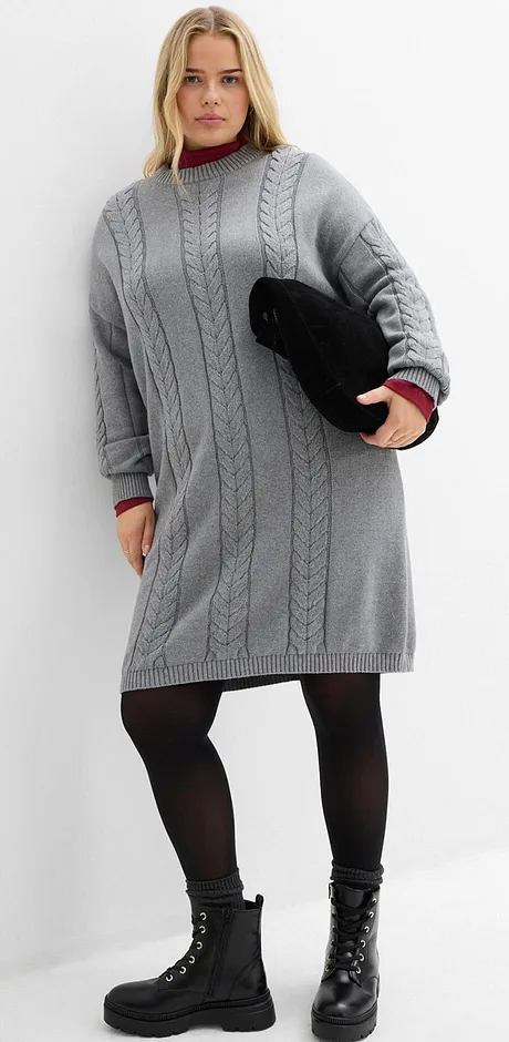 Grå stickad klänning, svarta strumpbyxor och stövlar med snörning.
