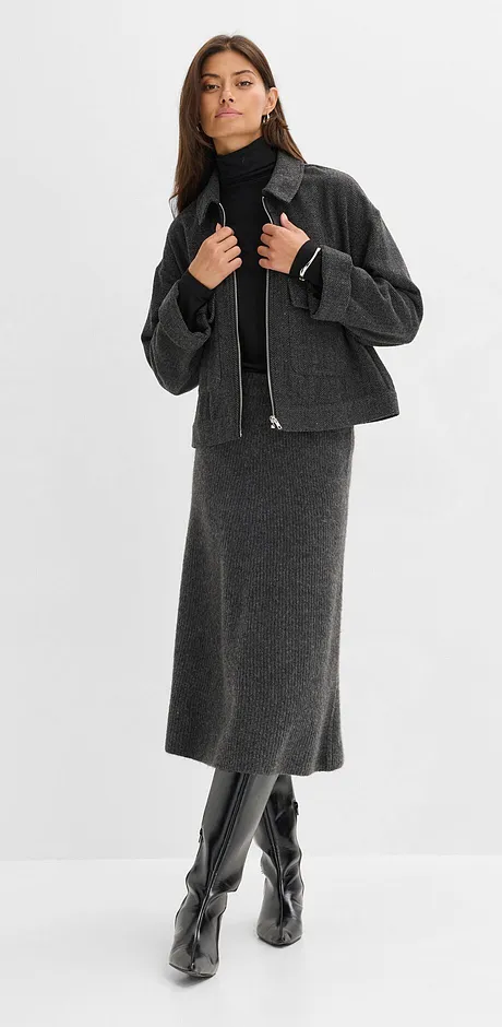 Grå yllerock, svart polotröja, kort jacka och knähöga läderstövlar.

