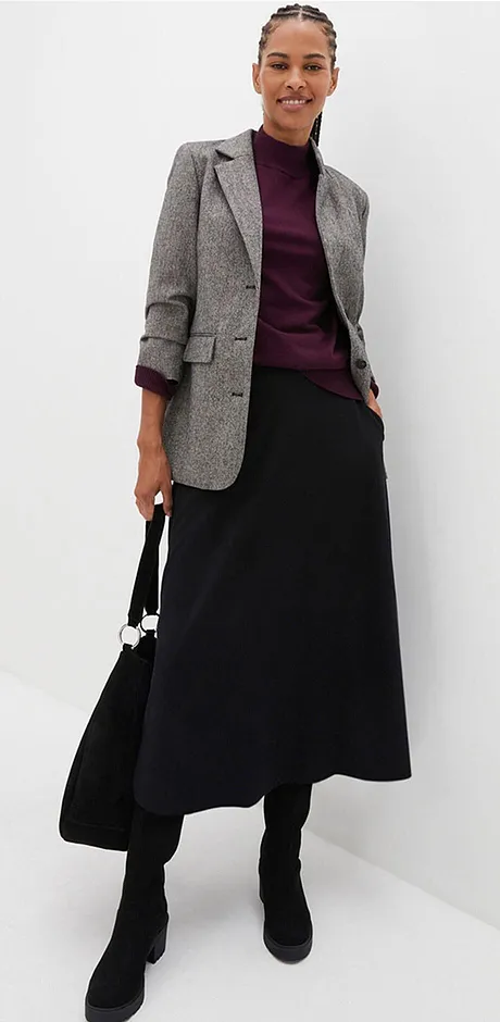 Rutig kavaj, lila topp och lång svart kjol.

