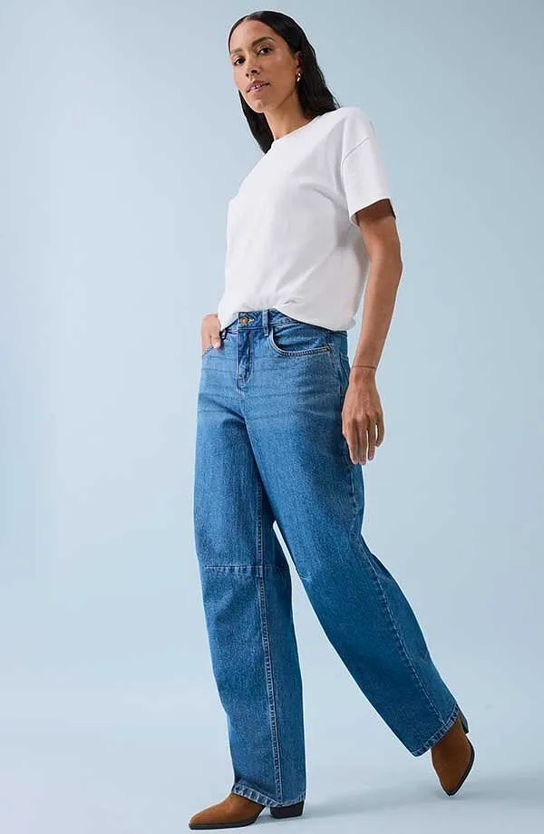 Klassisk vit T-shirt kombinerad med vida jeans och bruna skor.