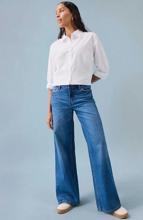 Vit skjorta till bl&aring;a jeans med vida ben samt vita skor.