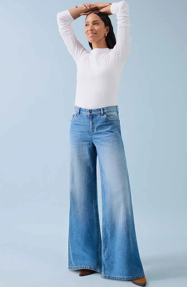 Vit l&aring;ng&auml;rmad topp och vida jeans: en kombination av komfort och ledig stil.