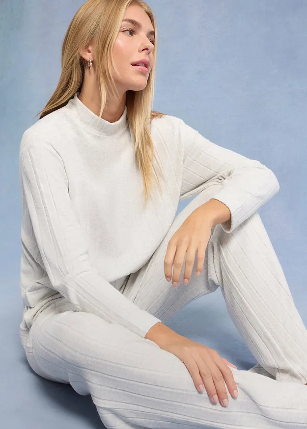 Elegant vit stickad tr&ouml;ja med st&aring;krage, perfekt kombinerad med matchande vita byxor.

