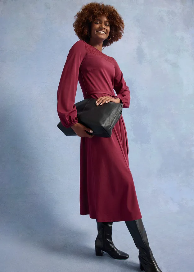 Elegant vinr&ouml;d kl&auml;nning med l&aring;nga &auml;rmar.

