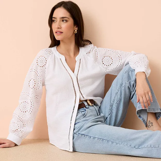 Vit l&aring;ng&auml;rmad blus med h&aring;lbroderi, kombinerad med ljusbl&aring; jeans och ett sk&auml;rp.

