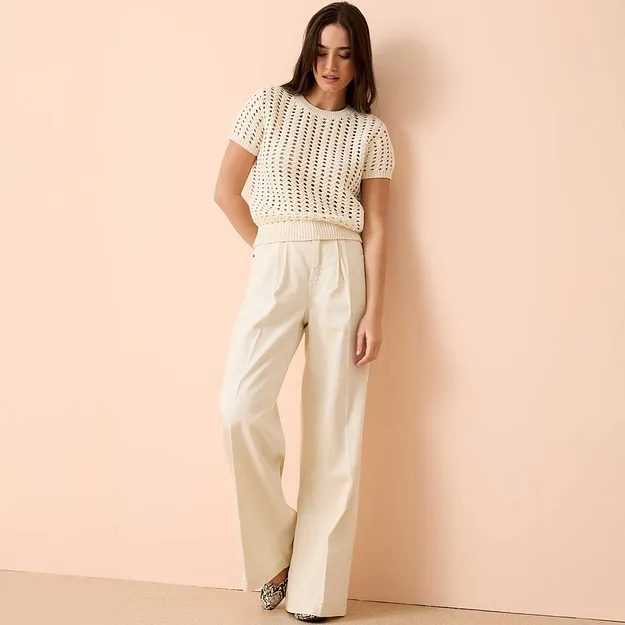 Virkad kort&auml;rmad topp kombinerad med vida, fl&ouml;dande jeansbyxor.

