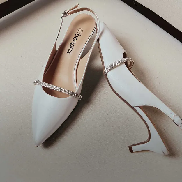 Eleganta vita pumps med tunn rem och spetsig t&aring;. Stilfull sko f&ouml;r speciella tillf&auml;llen.

