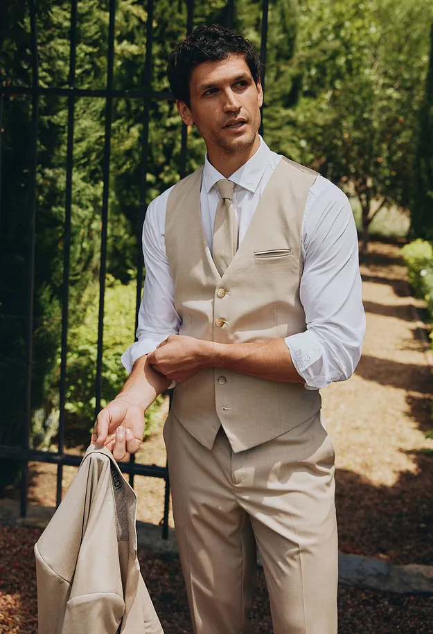 V&auml;st, byxor och kavaj. D&auml;rtill vit skjorta och slips.

