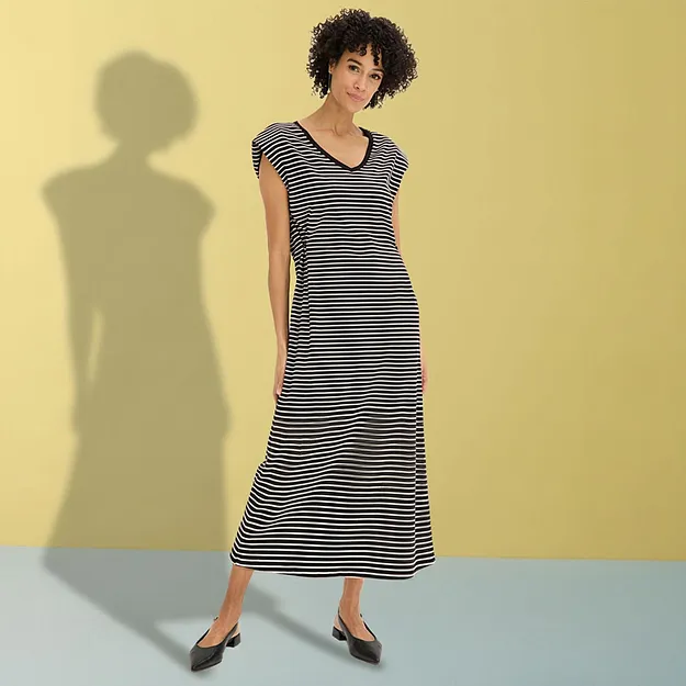 Elegant svartvitrandig maxikl&auml;nning med V-ringning och svarta ballerinaskor.

