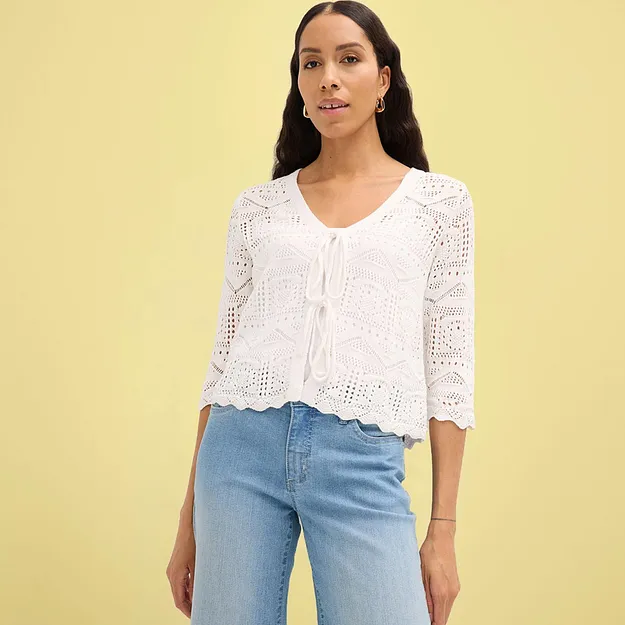 Vit virkad cardigan med halvl&aring;nga &auml;rmar kombinerad med bl&aring; jeans.

