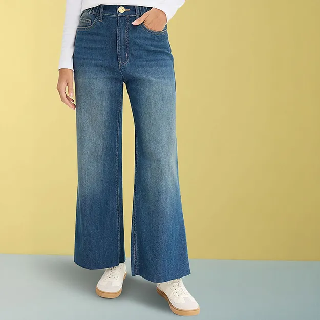 Vida jeans med vit topp och ljusa sneakers.

